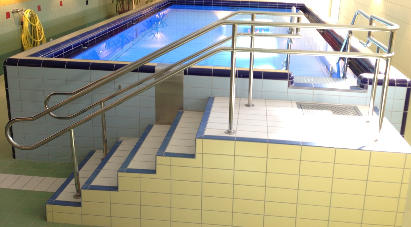Ett simbassängsräcke nedför en trappa i en bassäng.
